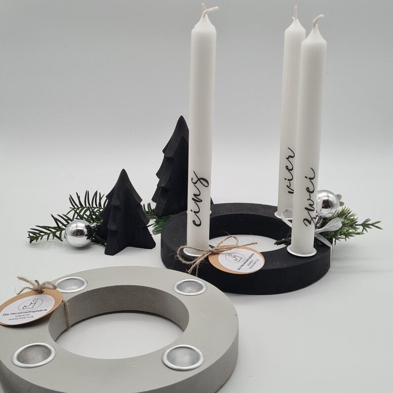 Grauer und schwarzer Beton-Adventskranz, festlich gestaltet mit Kerzen und winterlicher Dekoration