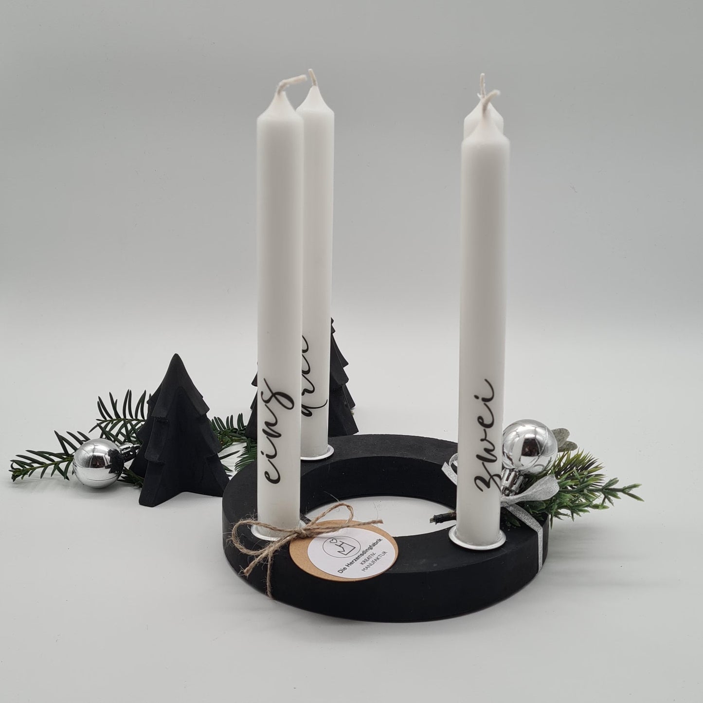Moderner handgefertigter schwarzer Beton-Adventskranz mit Kerzen, stilvoller Weihnachtsdeko und silberner Christbaumkugel