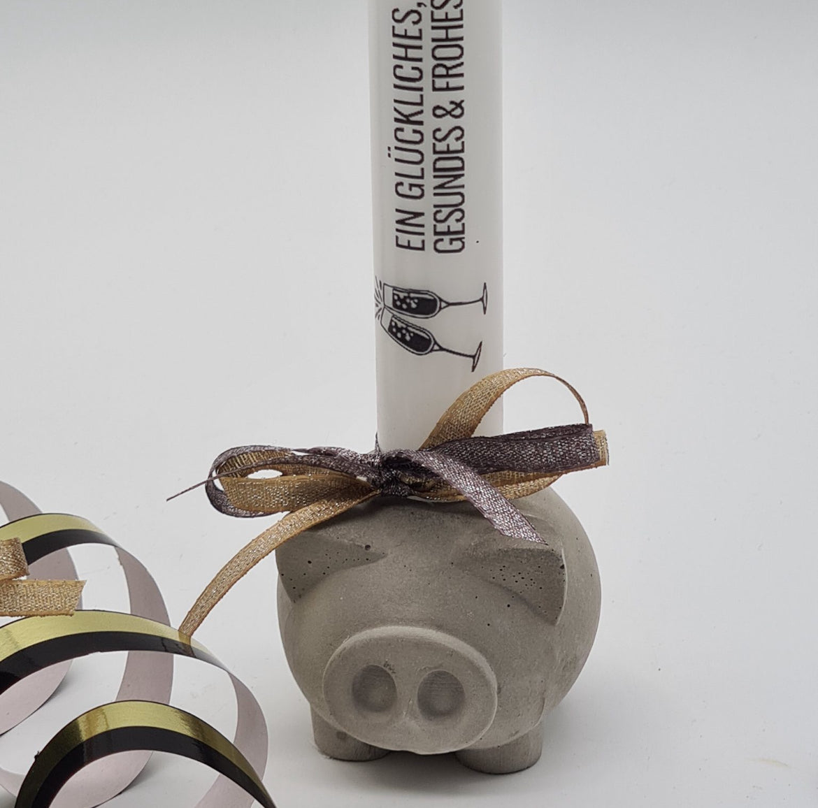 Detailansicht graues Beton-Glücksschweinchen „Piggy“ mit Stabkerze und Schleifenapplikation