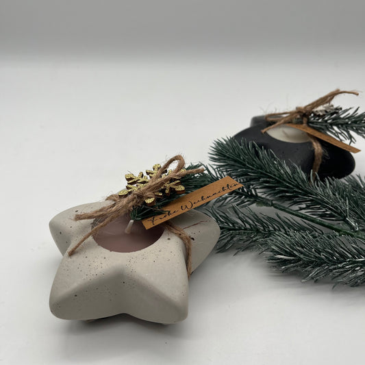 Handgefertigte Beton-Teelichthalter North Star in Grau und Schwarz auf Tannenzweig – stilvolle Weihnachtsdeko mit Duft nach Vanille und Schokoplätzchen.