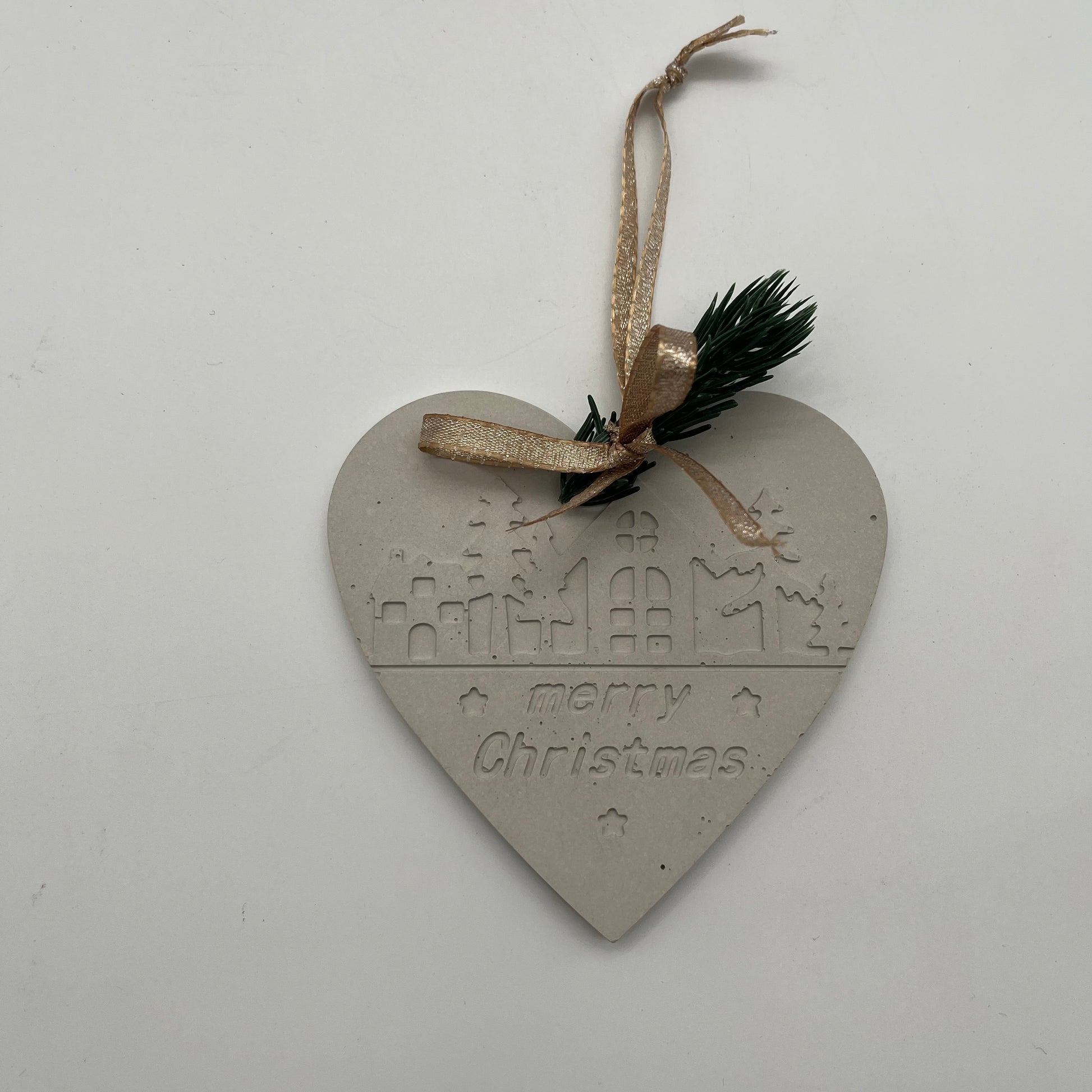 Grauer Beton-Anhänger Herz „Christmas Magic“ mit goldenem Aufhänger und Tannenzweig.