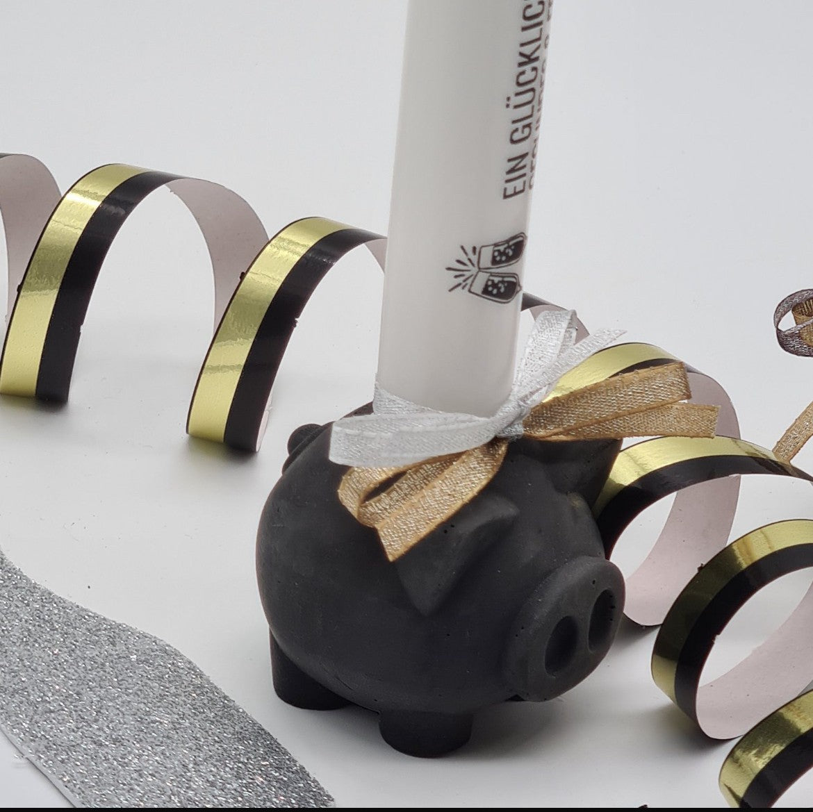 Handgefertigtes Beton-Glücksschweinchen „Piggy“ in Schwarz, Detailansicht mit Stabkerze